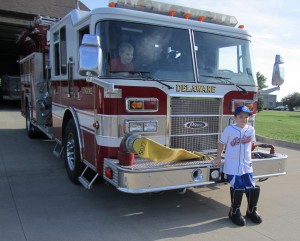 Mac in front of the fire dept with boots on