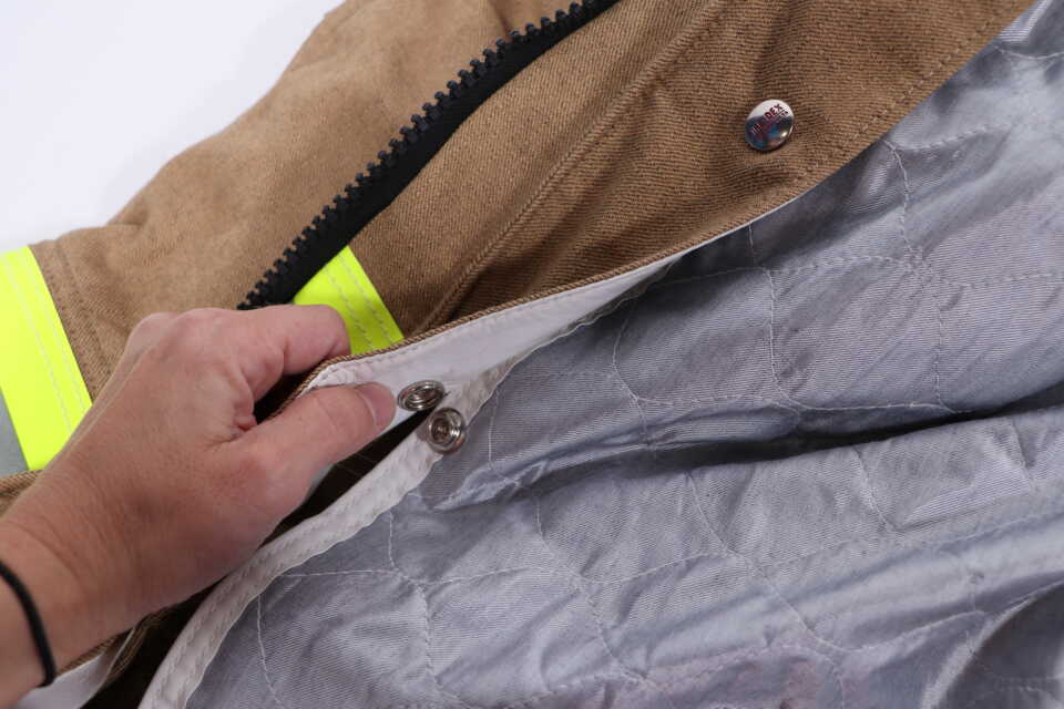 Remove the liner and thread the open end of the DRD through each slit under the flap on the back of the coat’s outer shell. 